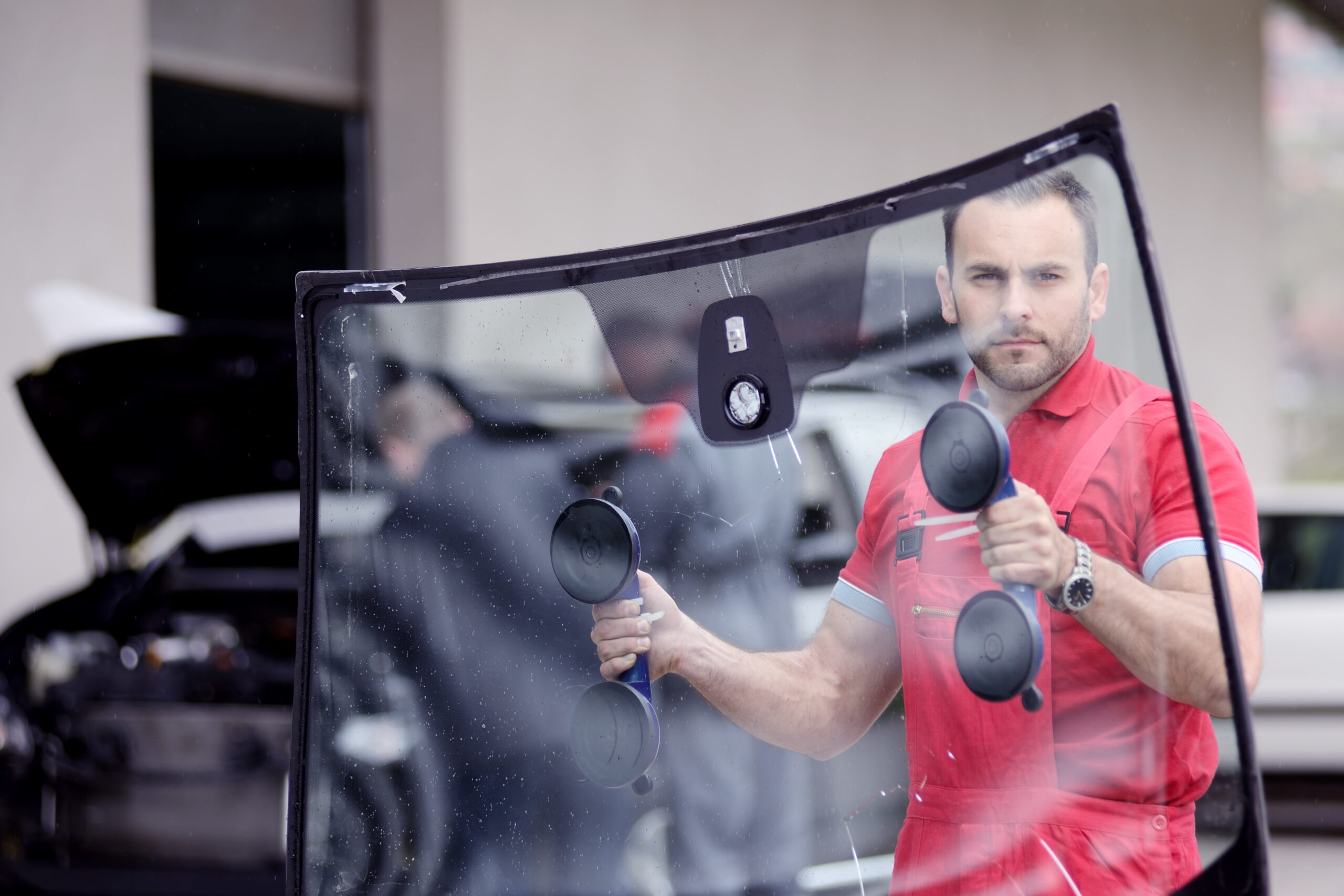 Technician performing a complete windshield replacement